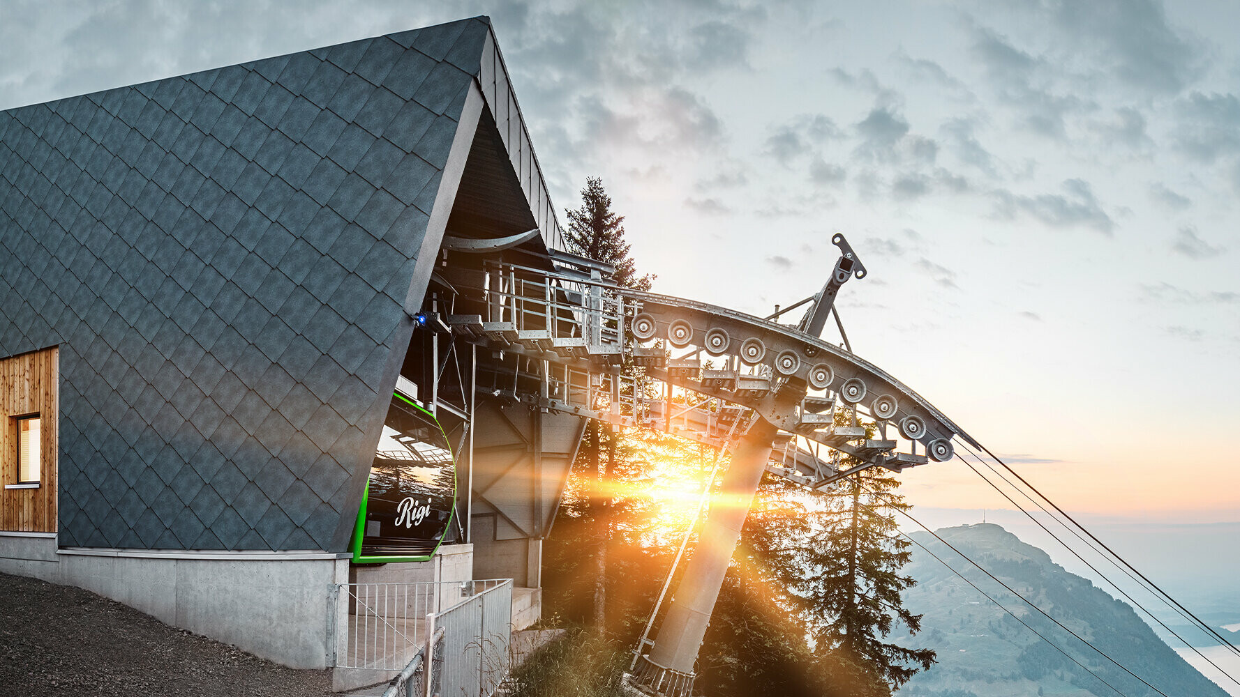 PREFA tetőfedő és homlokzatburkoló elemekkel fedett drótkötélpálya Svájcban naplementekor.
