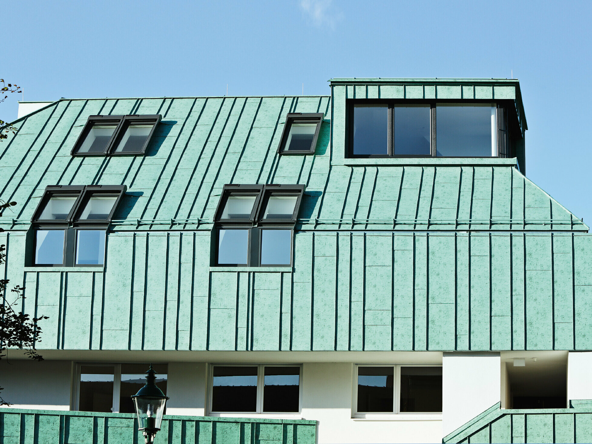 A PREFA patinazöld színű elemeivel készített PREFALZ tető- és homlokzatkialakítás, különböző sarniszélességekkel