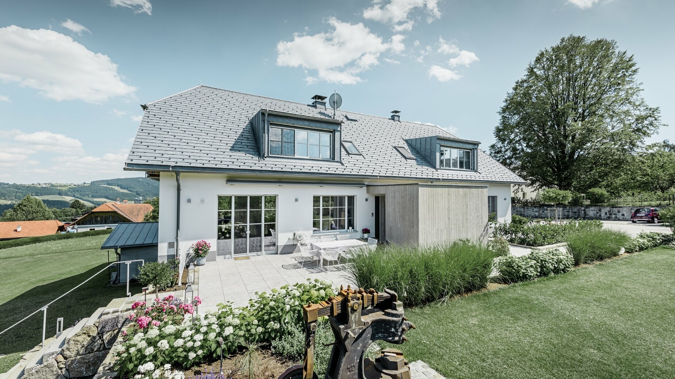 Klasszikus családi ház csonkakontyos tetővel; ház márványszürke színű PREFA tetőfedő zsindellyel felújított tetővel, gyönyörűen parkosított kerttel és tágas terasszal.
