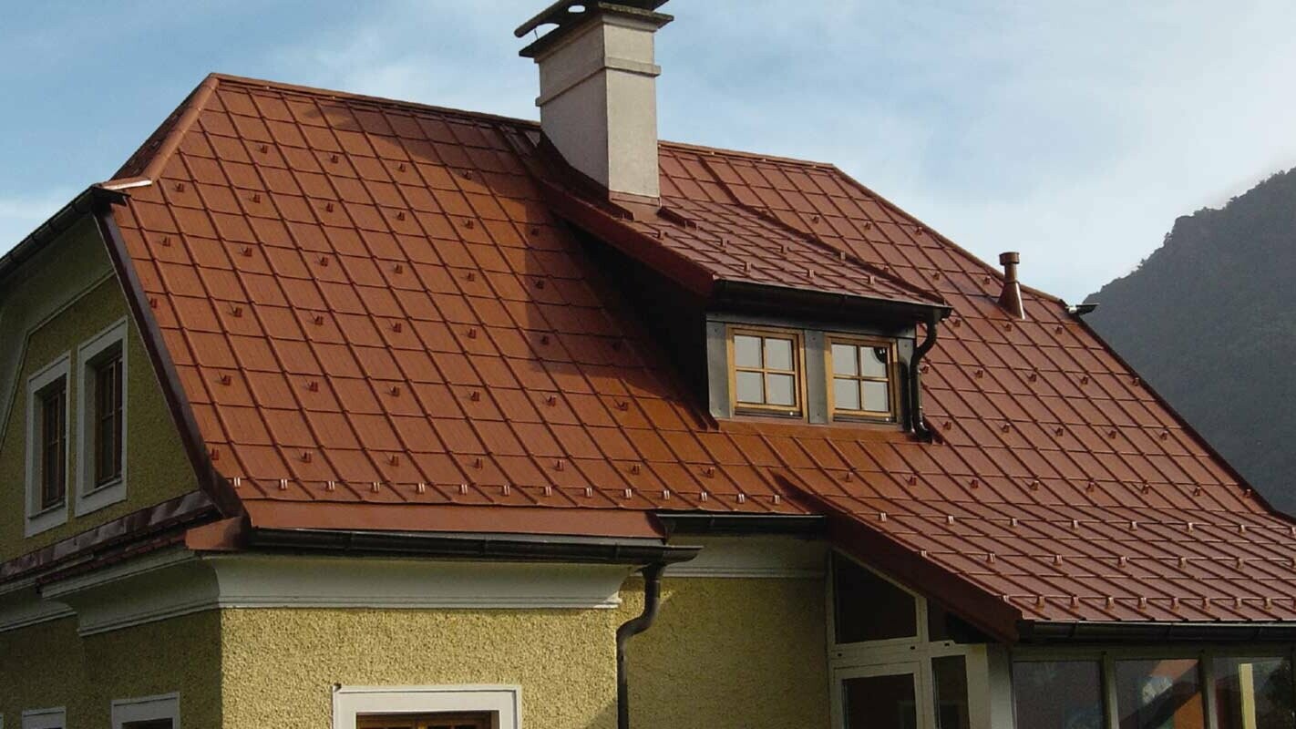 Csonka kontytetős családi ház és tetőablak PREFA Classic elemmel felújított tetővel, téglavörös színben
