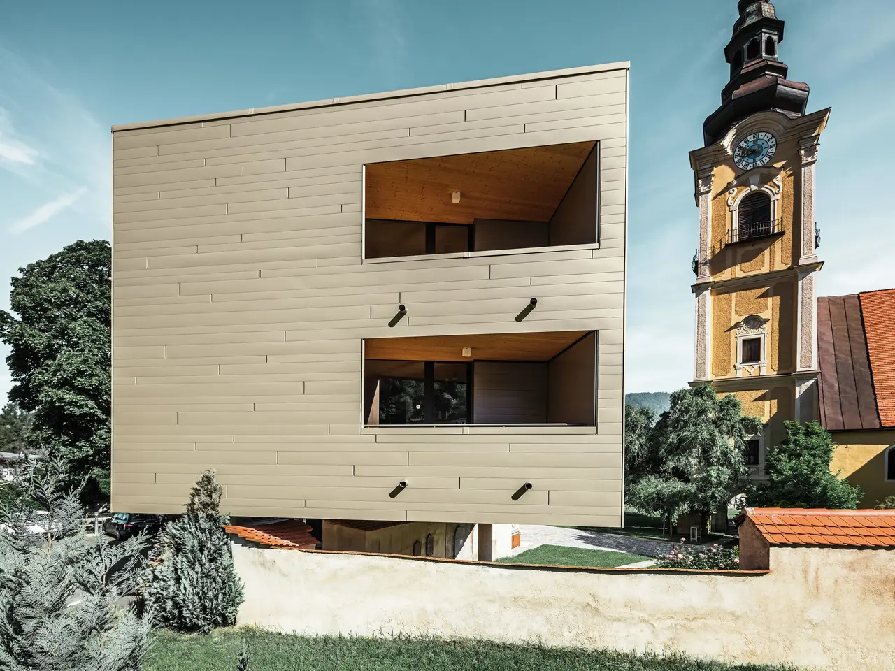 Seitenansicht des Studentenwohnheims in Leoben. Im Hintergrund ist die Kirche zu sehen.