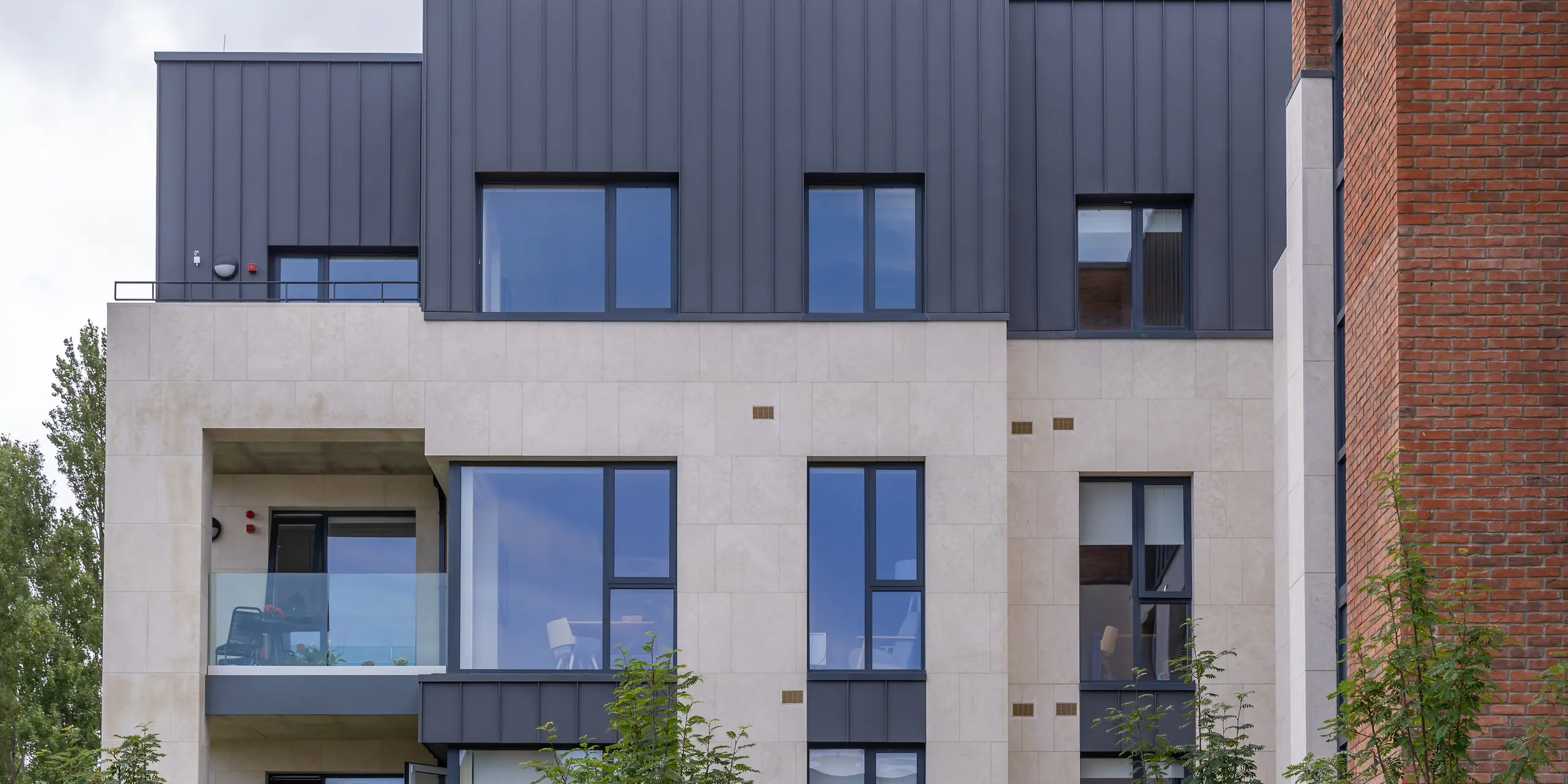 [Translate to Magyar:] Der Wohnkomplex der Oatlands Manor im Süden Dublins ist an der Fassade von PREFALZ in P.10 Dunkelgrau umhüllt