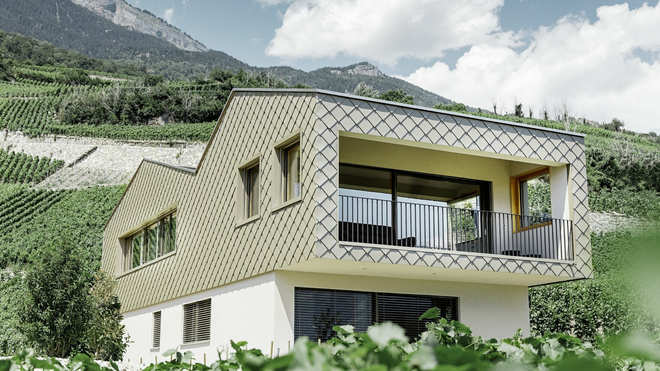 Modern családi ház Rhônetal szőlőhegyeinek közepén, 4 különböző tetősíkkal, nyitott galériával és bronz színű rombusz homlokzattal