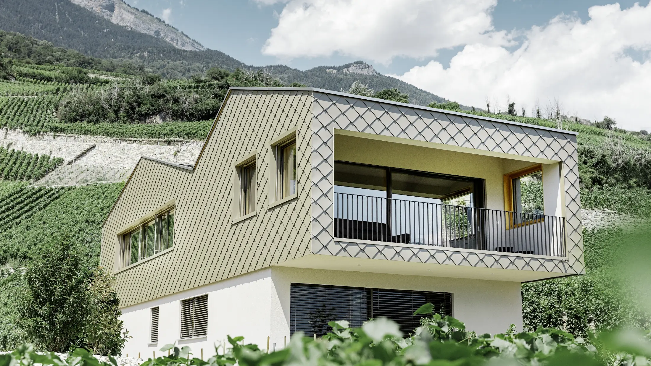 Modern családi ház Rhônetal szőlőhegyeinek közepén, 4 különböző tetősíkkal, nyitott galériával és bronz színű rombusz homlokzattal