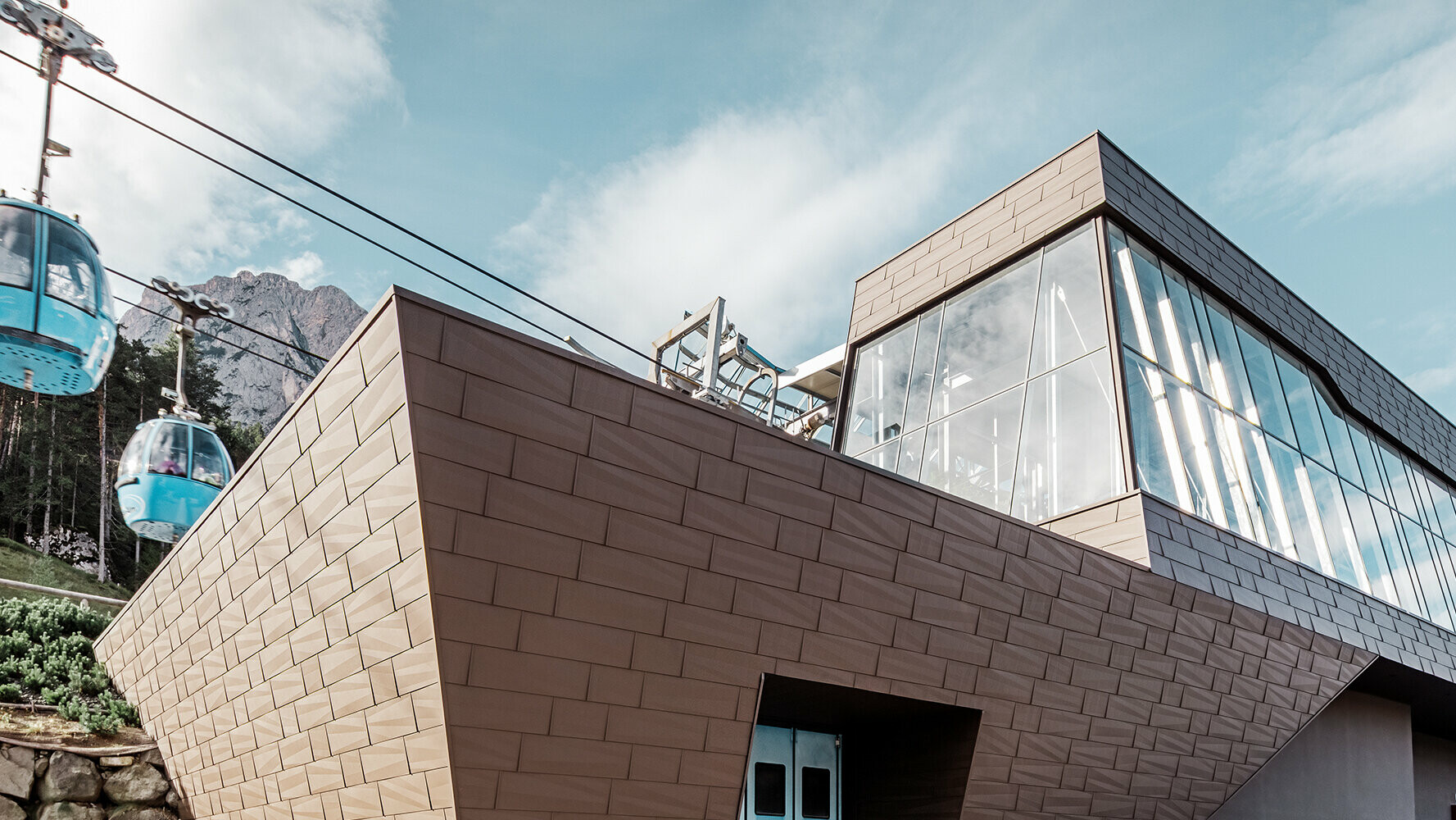 Egy dél-tiroli kötélpálya völgyállomása modern, barna színű PREFA tető- és homlokzatburkolattal.