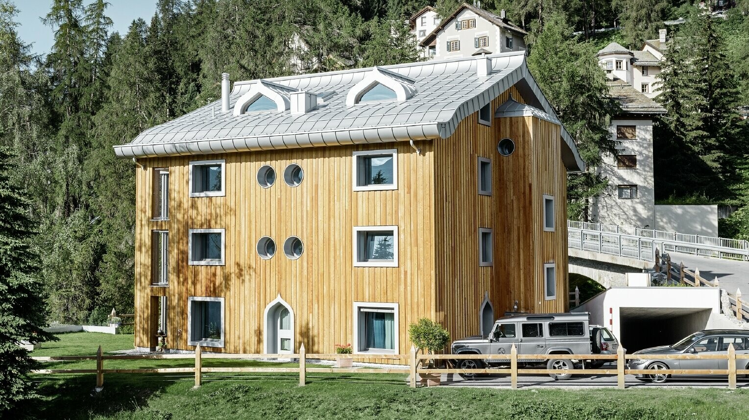 Lakónegyed St. Moritzban fa homlokzattal és alumínium fedéssel, íves eresszel, ezüstmetál színben