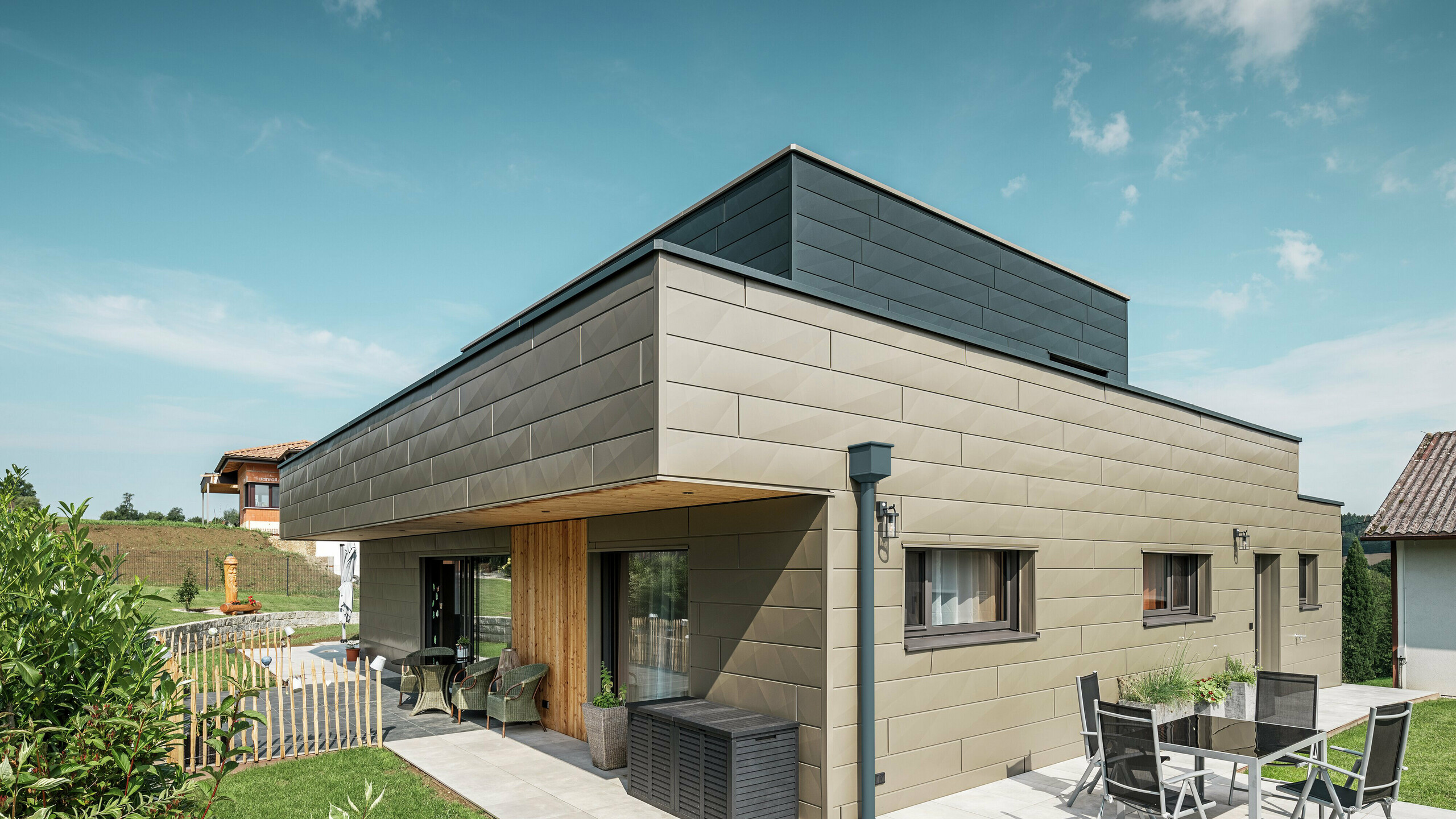 A kiállításon egy wippenhami családi ház látható, amelynek homlokzata kéttónusú, P.10 Prefabronze és P.10 Anthracite színű Siding.X anyagból készült.