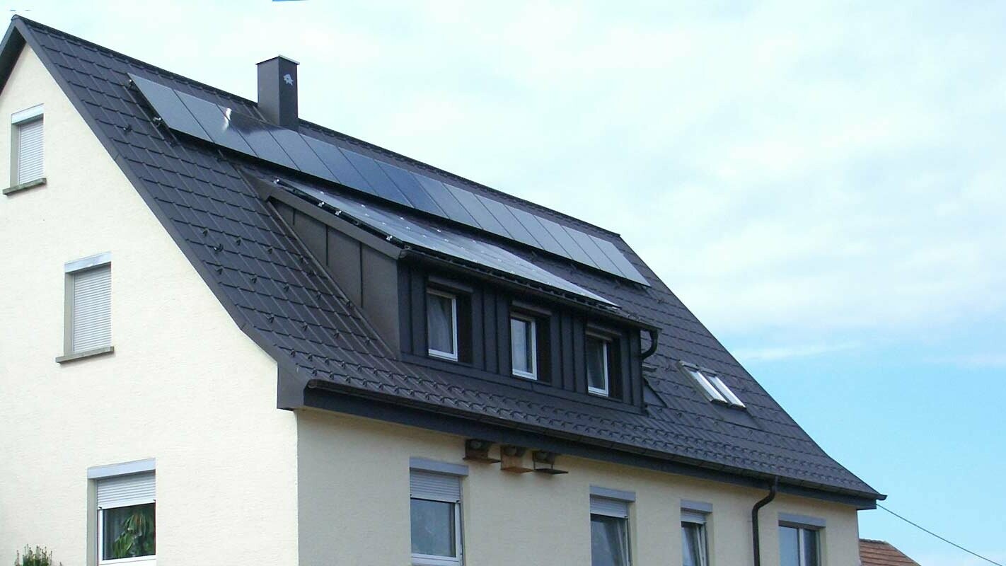 antracit színű, PREFA Classic elemmel felújított tető, a tetőablakokat Prefalz borítja; a tetőn fotovoltaikus berendezés található.