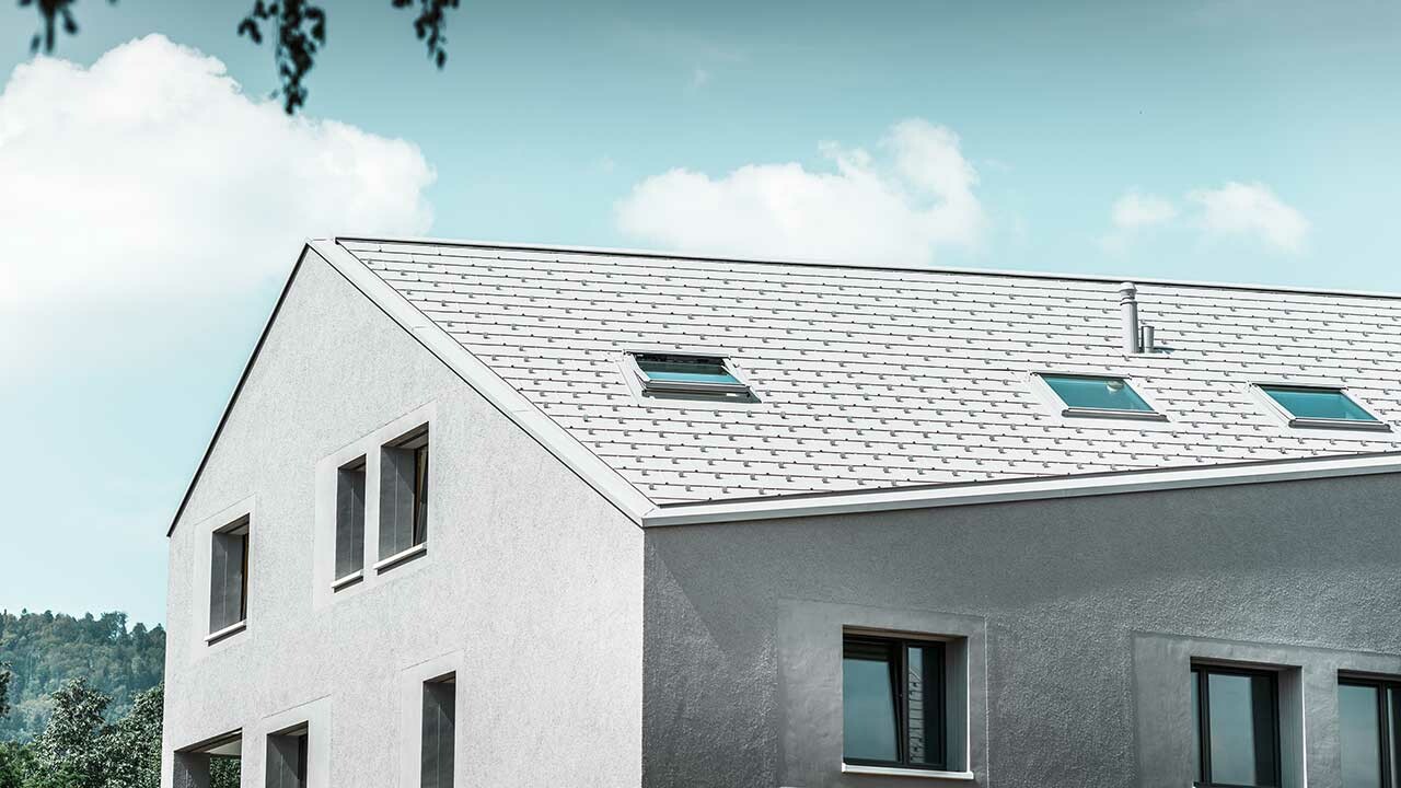 Mehrparteienhaus mit schräger traufe und weißem Dachpaneel FX.12.