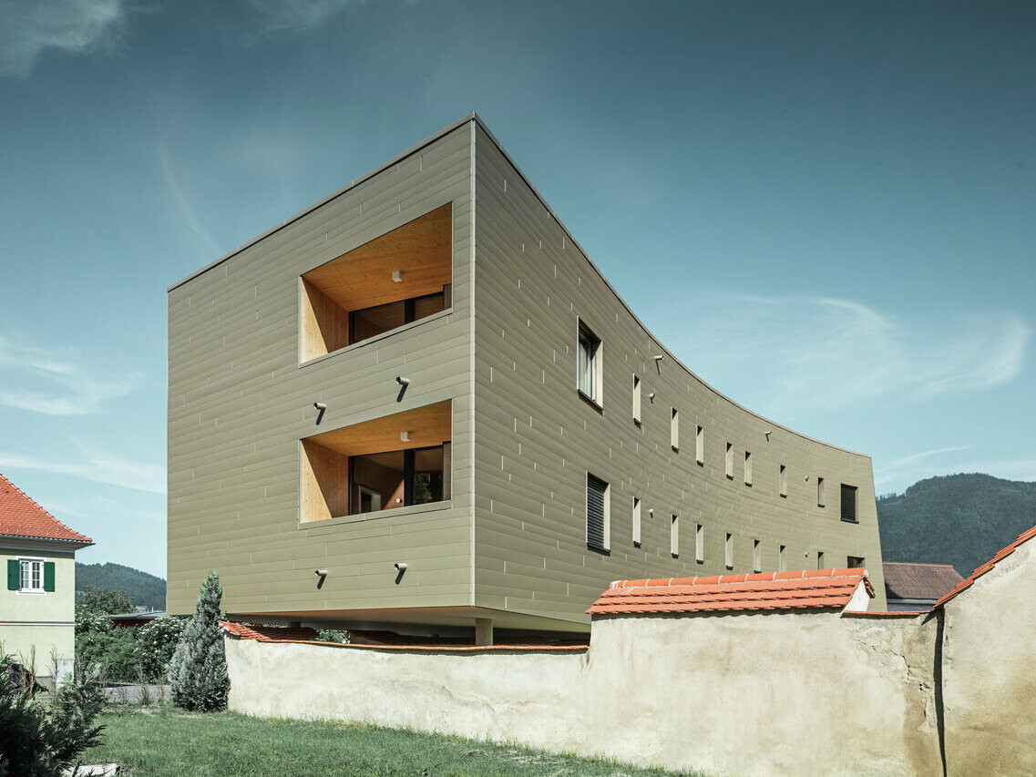 Zu sehen ist das leicht gebogene Wohnheim für Studenten, wobei die neu renovierte Fassade in der Farbe Bronze zur Geltung kommt.