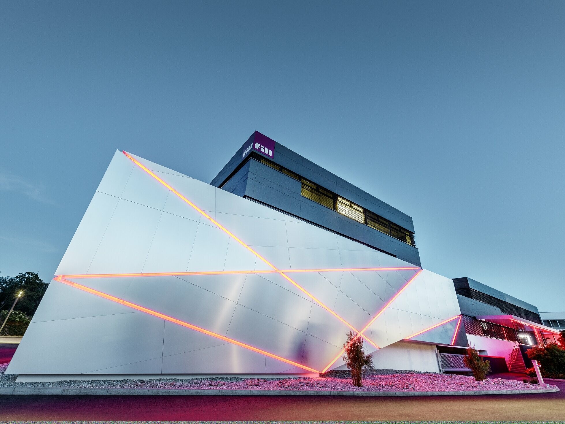 Fill Székház futurisztikus, szálcsiszolt alumínium kompozit lemez homlokzatburkolattal, megvilágított fugákkal