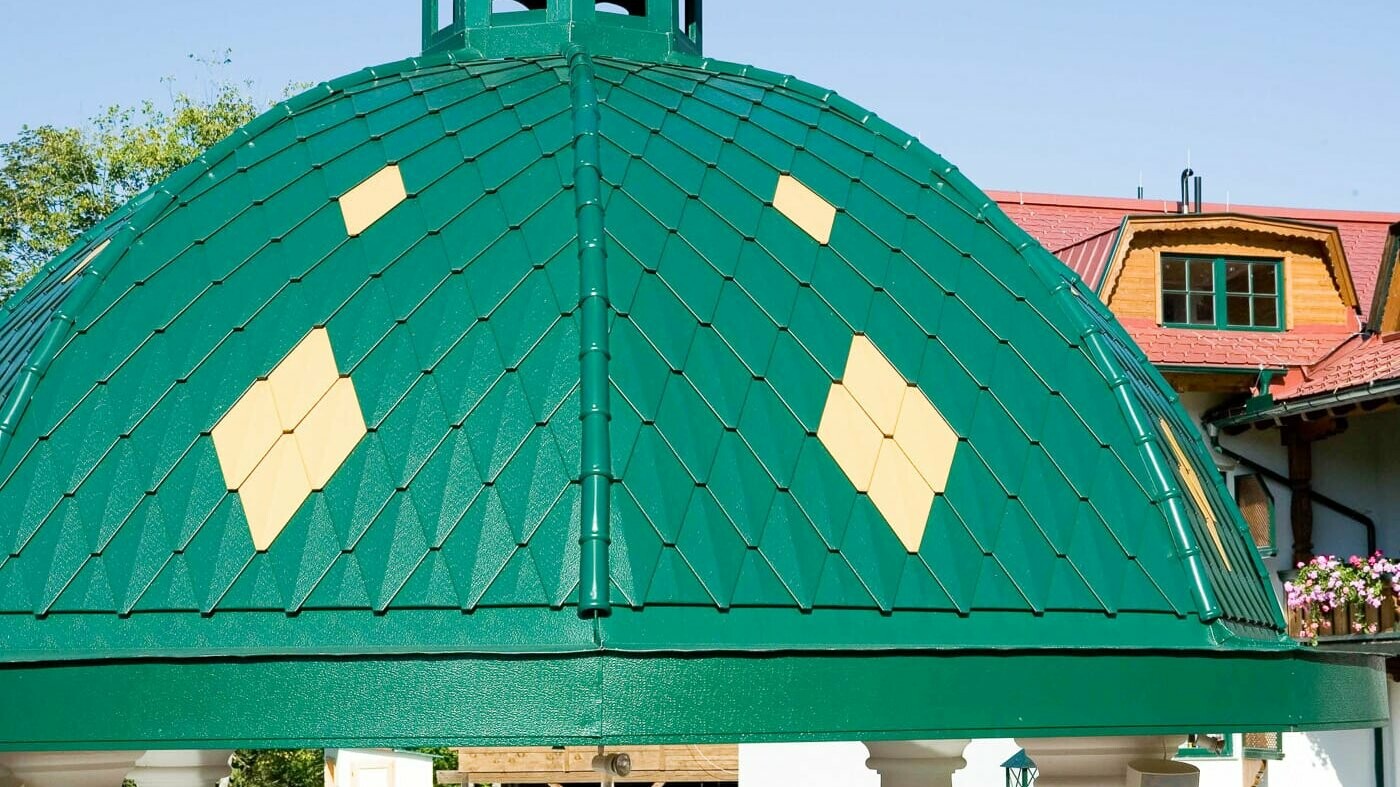 kerek kupola, amelyet mohazöld PREFA kis rombusz borít