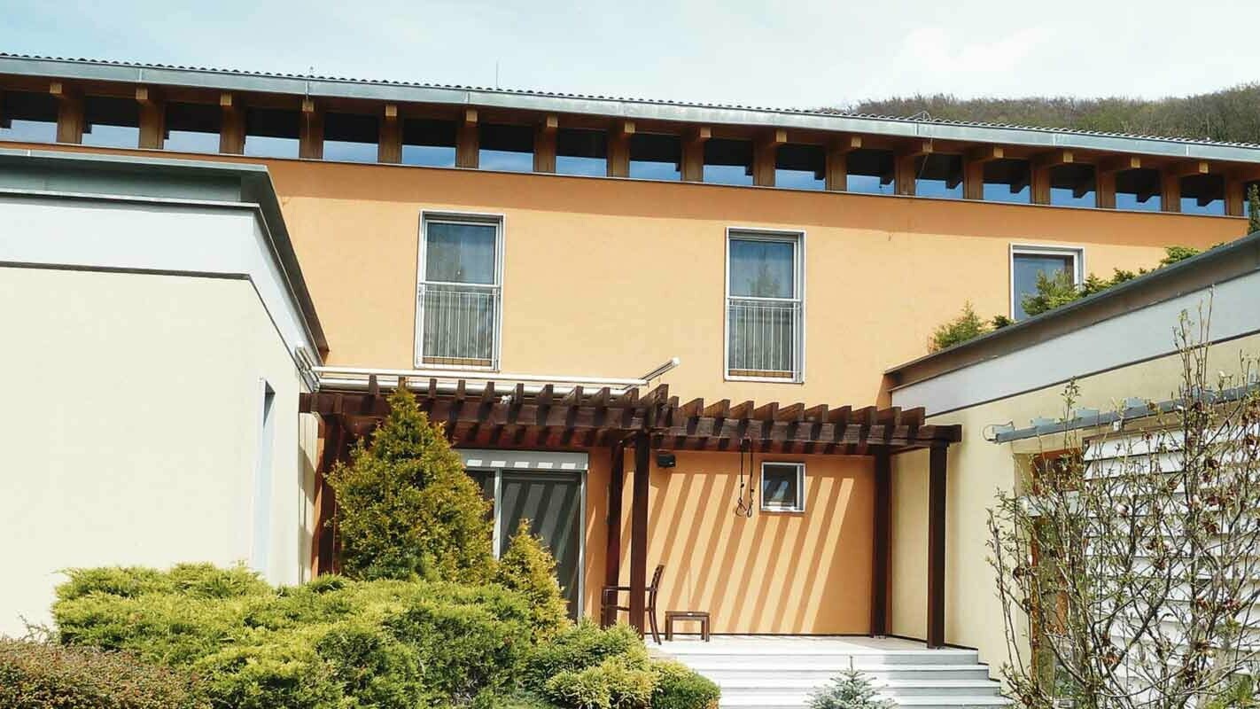 Modern családi ház homlokzatfelújítás előtt, PREFA FX.12-es homlokzatburkoló panel P.10 antracit színben, narancssárga homlokzat