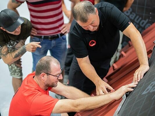 PREFA oktatóburkoló a PREFA Academy oktatóközpontban bemutatja az egyik résztvevőknek a