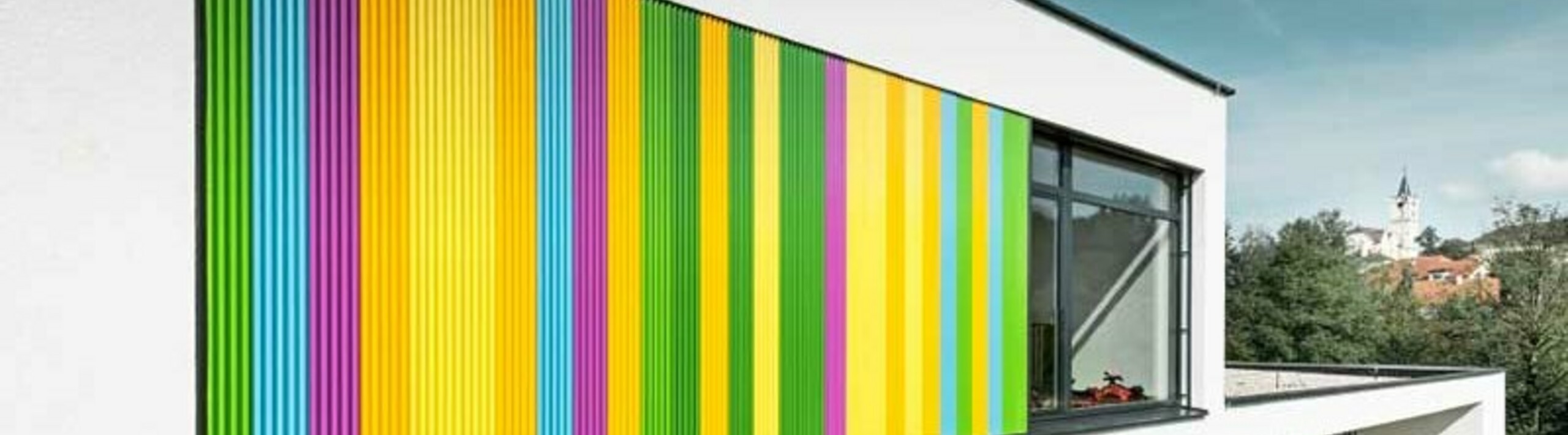 PREFA fogazott profillal díszített modern óvoda színes homlokzati részletei