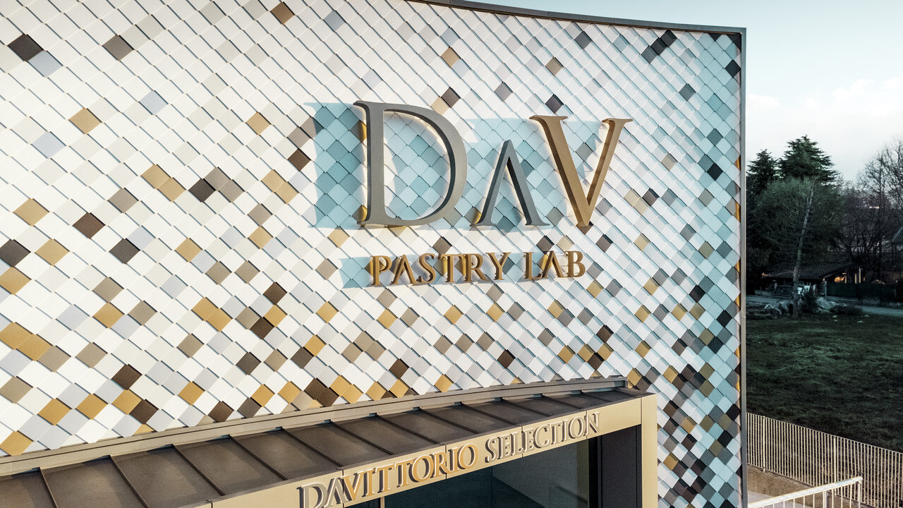 A bergamói DAV Pastry Lab cégépülete tarka rombusz alakú homlokzattal P.10 barna, bronz, P.10 sötétszürke, mayagold, natúr alumínium, P.10 prefafehér és P.10 tisztafehér színekben 