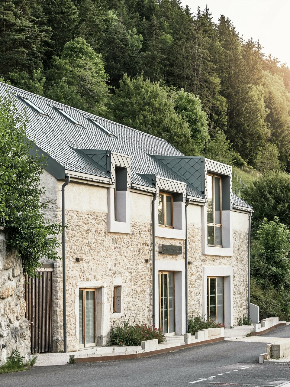 Obnovljena štala "La Grange à Gaby" u Enginsu, Francuska, spaja tradicionalno kameno zidanje s modernim PREFA aluminijskim krovom izrađenim od rombova veličine 29 × 29 cm. Obnova povezuje povijesni stil gradnje sa suvremenom arhitekturom i održivim materijalima.