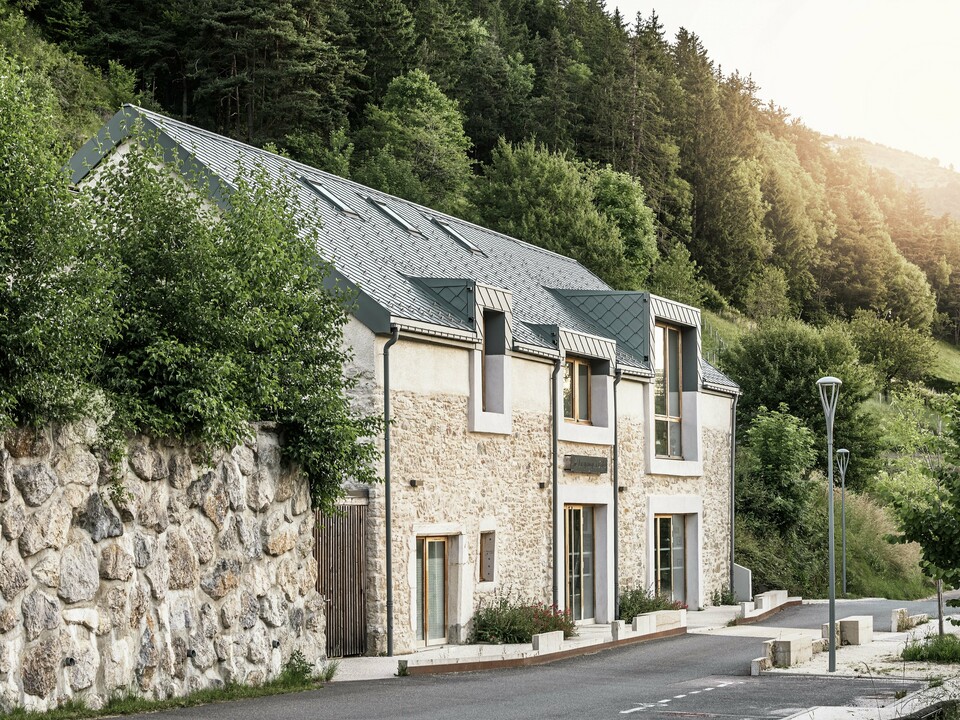 Obnovljena štala "La Grange à Gaby" u Enginsu, Francuska, spaja tradicionalno kameno zidanje s modernim PREFA aluminijskim krovom izrađenim od rombova veličine 29 × 29 cm. Obnova povezuje povijesni stil gradnje sa suvremenom arhitekturom i održivim materijalima.