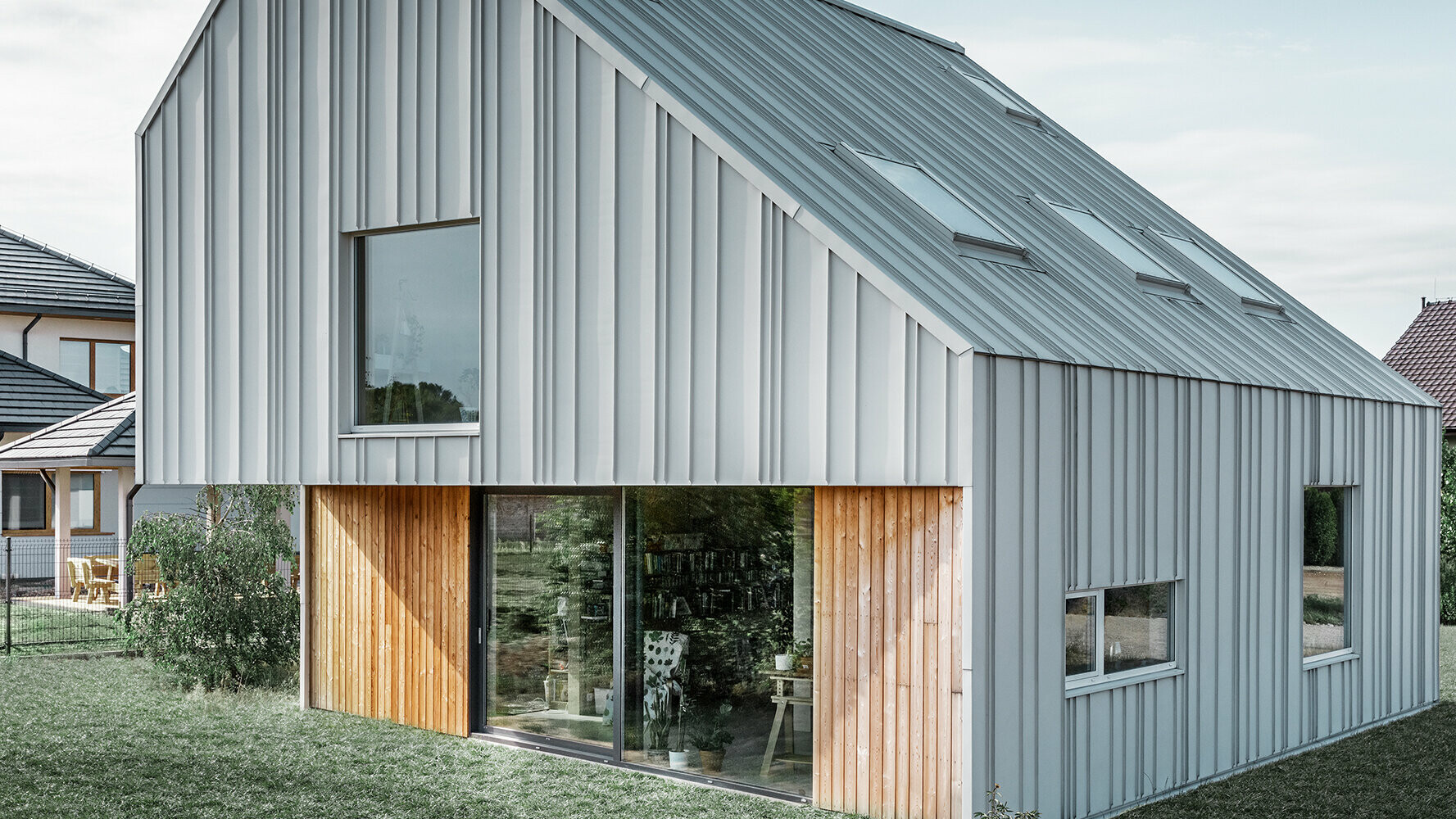 Modern családi ház különböző szélességű PREFALZ tetőfedő és homlokzatburkoló panelekkel