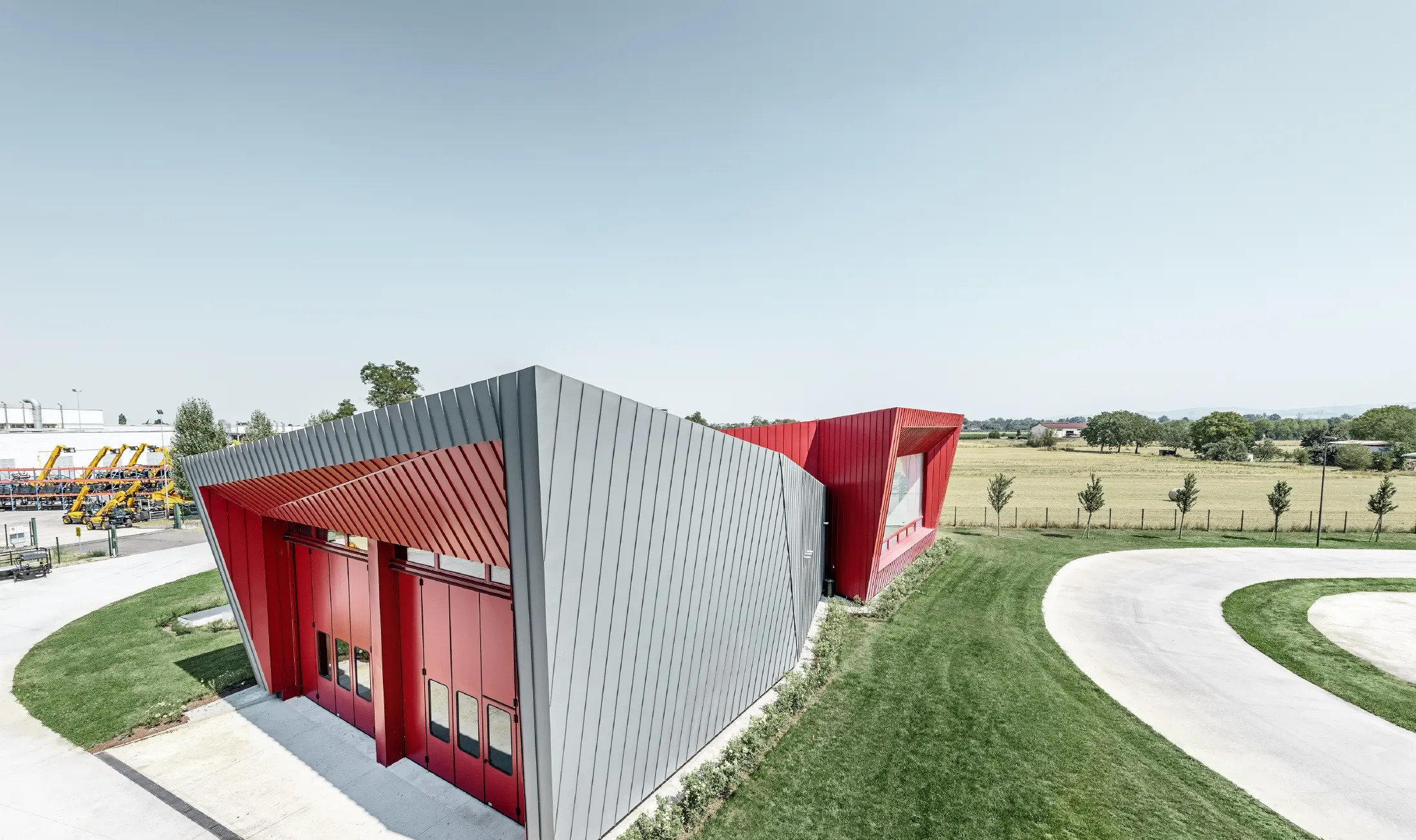 Modern oktatóközpont Dieciben, Olaszország Montecchio Emilia tartományában, világosszürke Prefalz és karmazsinpiros Falzonal alumínium homlokzattal burkolt lelátóval.