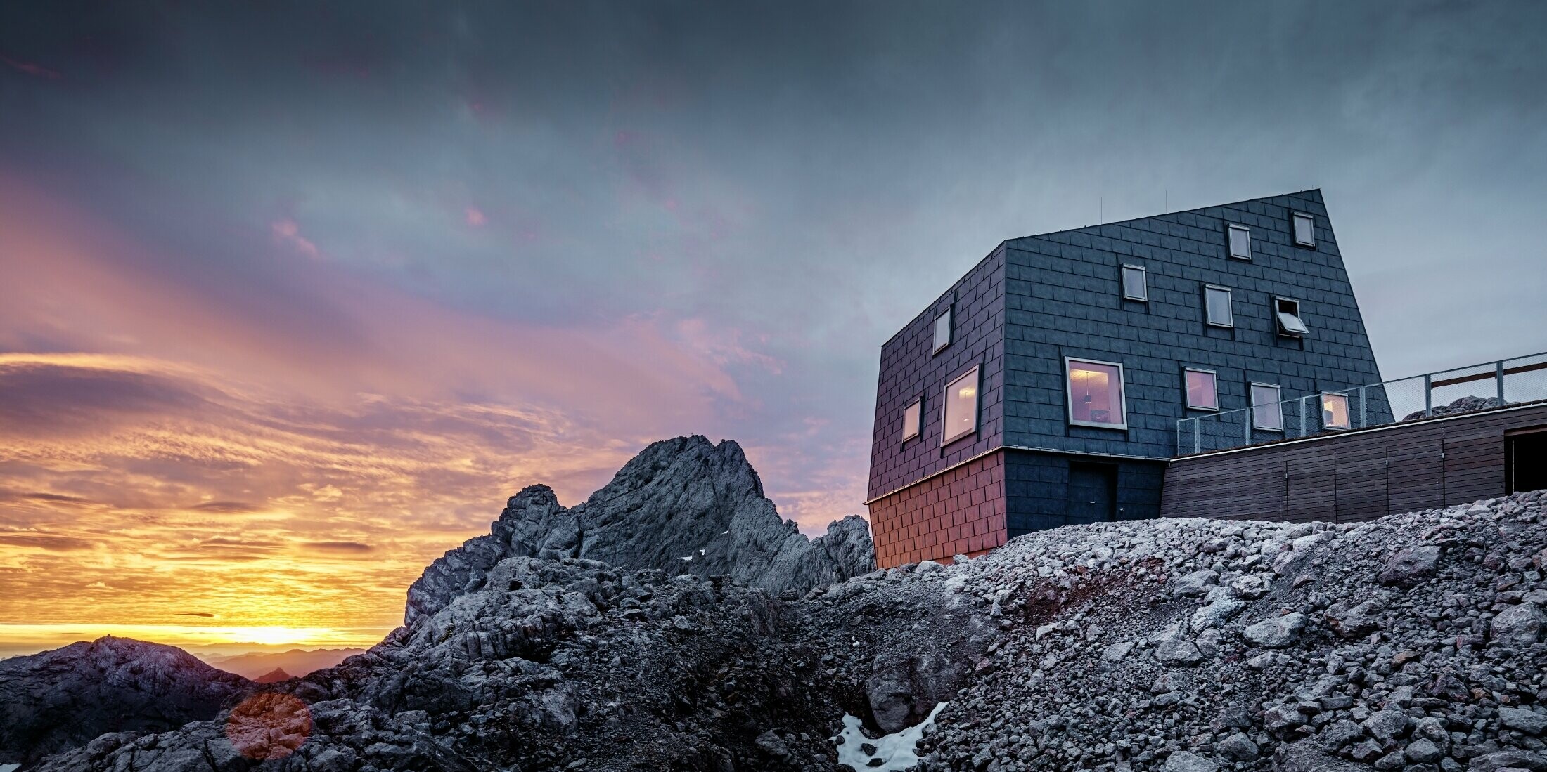 A Dachstein-gleccsernél, a természetvédelmi terület közepén elhelyezkedő új Seethalerhütte karcsú szerkezetével és sziklához hasonló homlokzatával nyűgöz le. A ferde falaknak, valamint a P.10 kőszürke színű PREFA FX.12 tető- és homlokzati paneleknek köszönhetően a menedékház minden időjárásnak ellenáll.