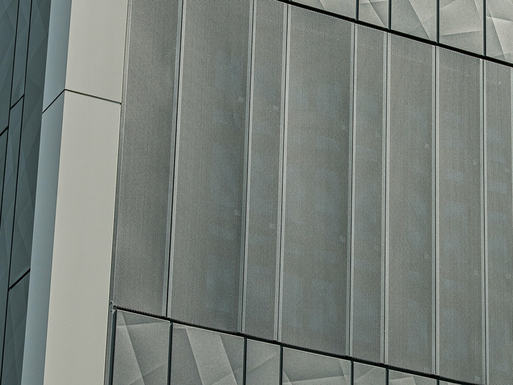 Egy Eurospar áruház homlokzata Rohrbachban, PREFA Siding.X és perforált burkolatokkal, antracit színben. A Siding.X elemek élénk, geometrikus fugaképet mutatnak, míg a perforált burkolatok modern, légáteresztő szerkezetet biztosítanak.