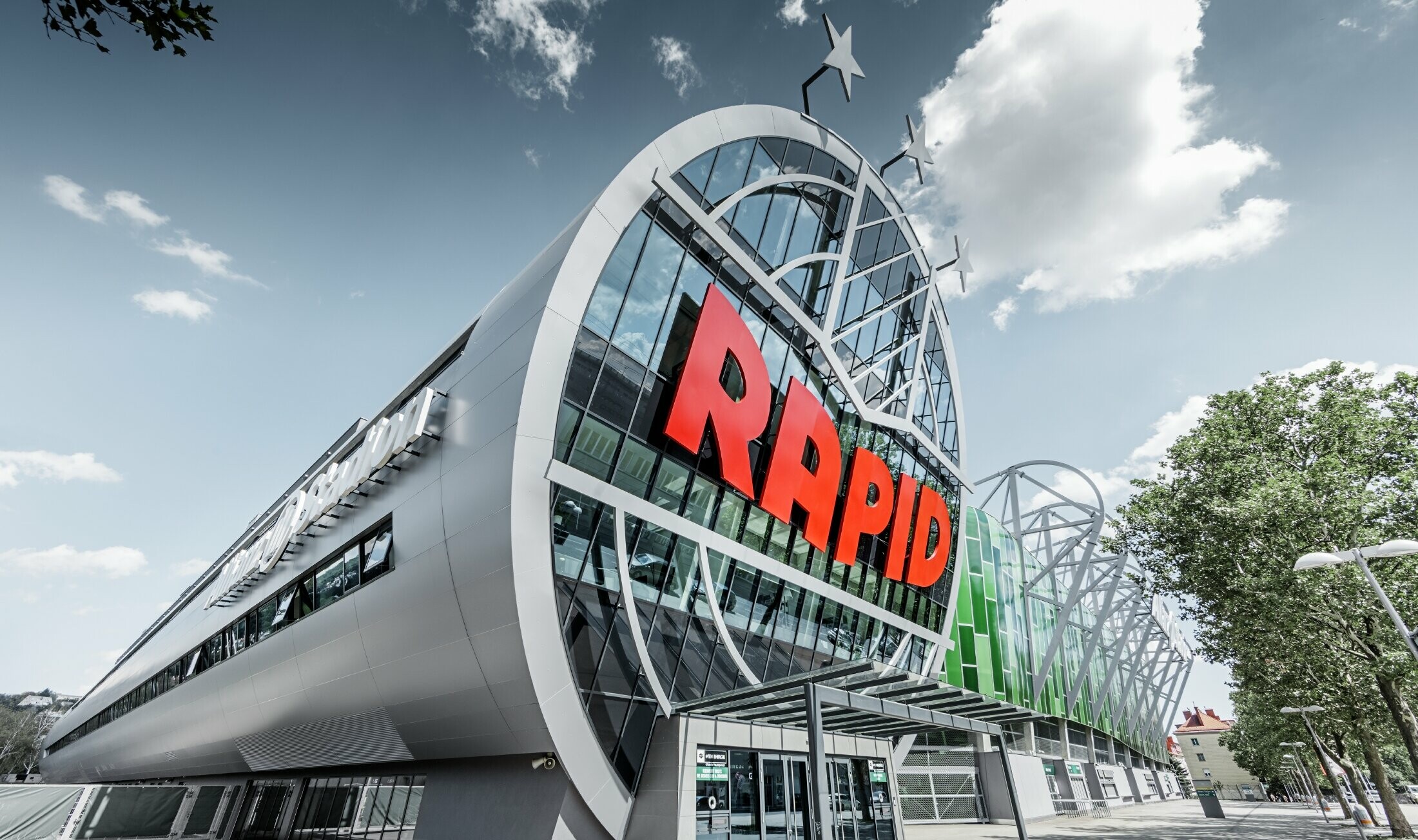 Der Eingang ins Allianz Stadion mit dem großen SK Rapid Wien Logo; Die Röhre mit der großen Glasfront ist mit der PREFA Aluminium Verbundplatte in Silbermetallic eingedeckt.