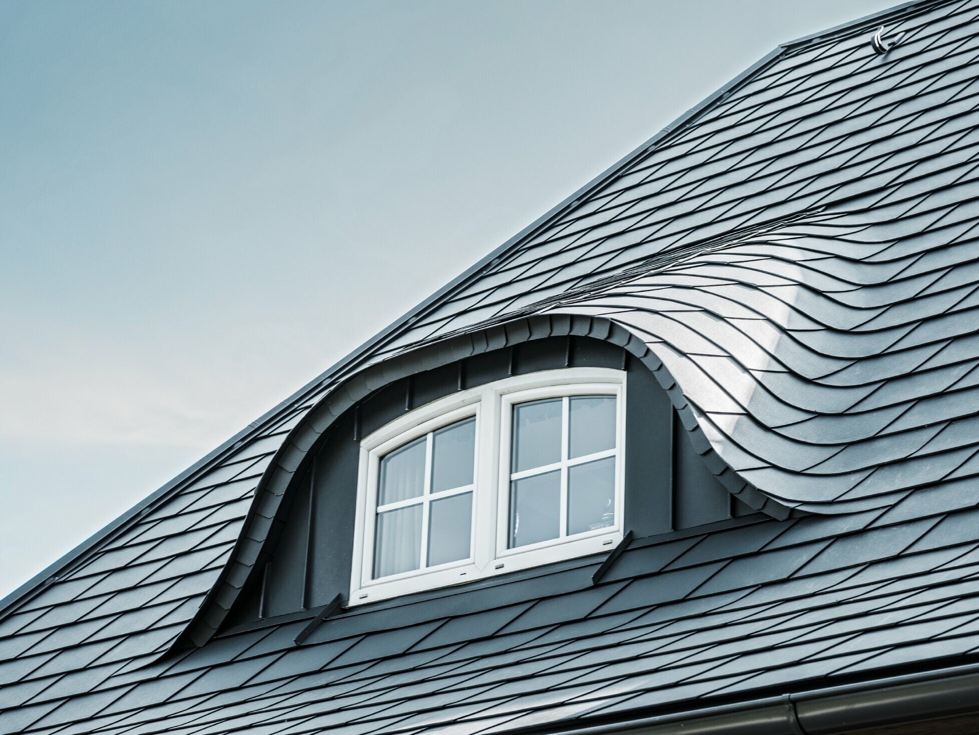 Nemrég felújított tető ívelt kiugró tetőablakkal, P.10 antracit színű PREFA alumínium zsindellyel burkolt ablakkal 