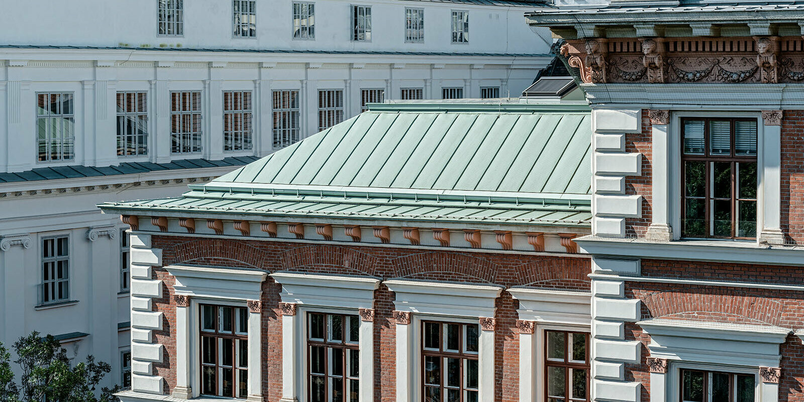 Eine Detailansicht des Dachsystem Prefalz von PREFA in der Farbe Opalgrün der Evangelischen Volkschule am Wiener Karlsplatz.