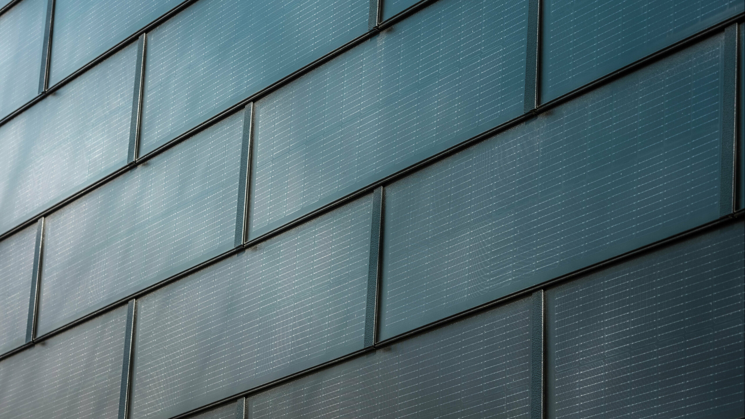 Közelkép a PREFA napelemes tetőlemezekről, amelyek egy homlokzatra lettek felszerelve.