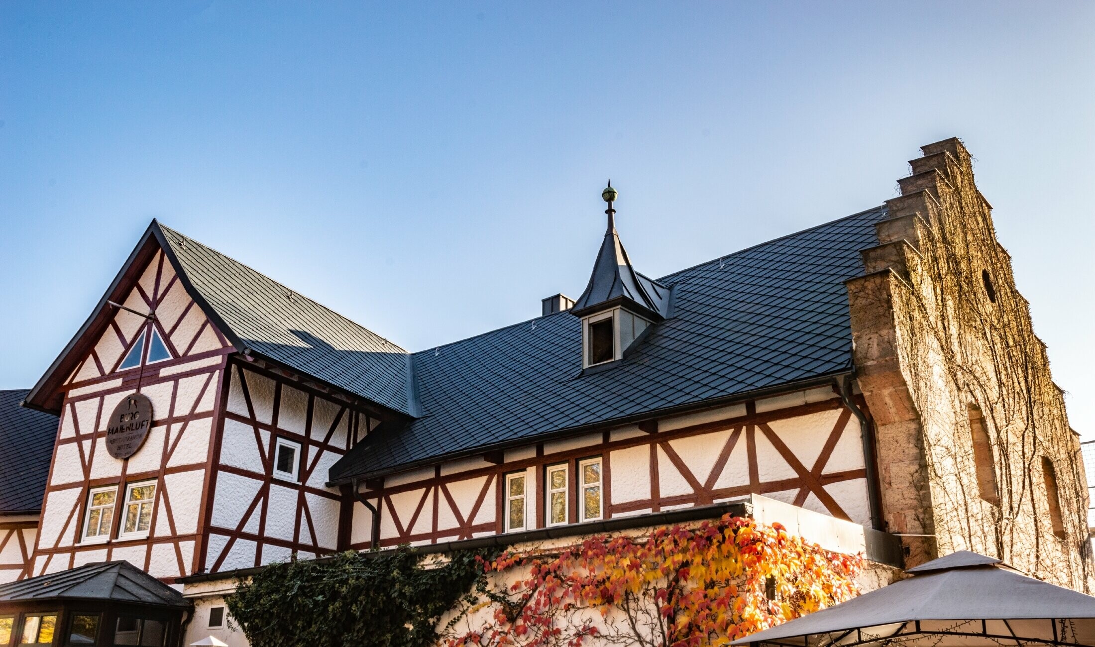 Das Hotel Burg Maienluft wurde mit der PREFA Dachraute 29 × 29 in Anthrazit neu eingedeckt, die Fassade ist eine Fachwerk-Fassade.