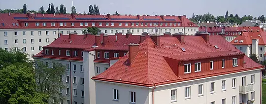 Felvétel a bécsi Hugo Breitner Hof lakóházairól. A tetőket téglavörös PREFA zsindellyel fedték.