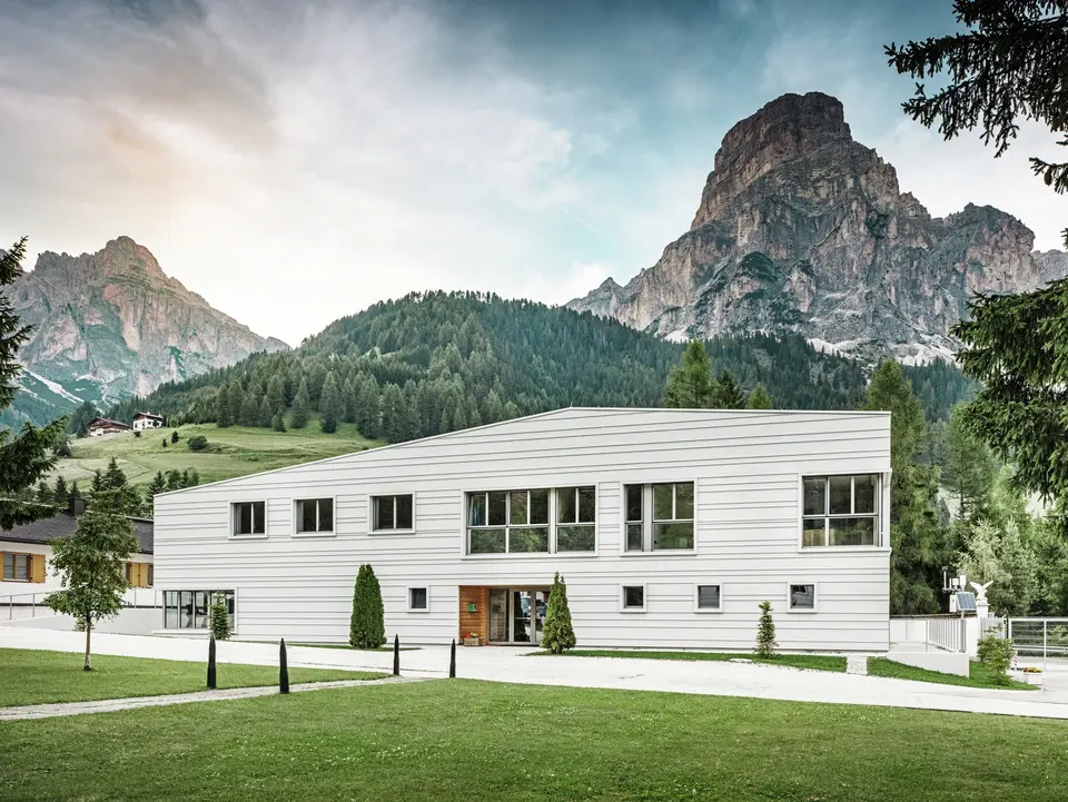 Moderne Militärarchitektur trifft auf alpine Landschaft: Die Kaserne „Tempesti“ liegt inmitten der Südtiroler Landschaft vor einer imposanten Bergkulisse. Die helle PREFALZ-Fassade in der Farbe P.10 Prefaweiß setzt klare Linien. Das helle Aluminium reflektiert das Sonnenlicht und verbessert das Raumklima.