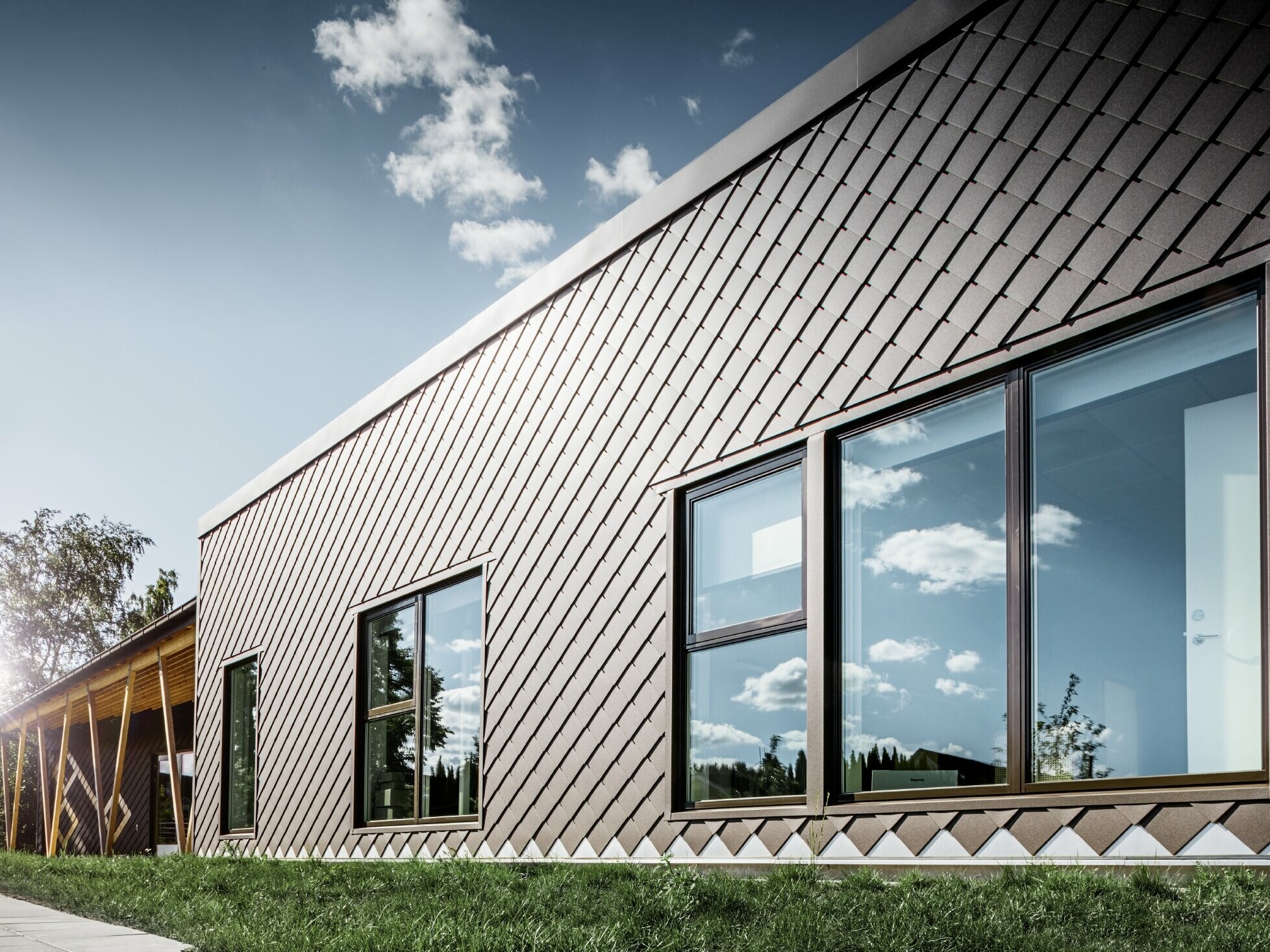 Ezen a stockholmi óvodáról készült fotón az új homlokzat látható nagy ablakokkal és lapos tetővel. A külső homlokzatot 20x20-as barna homlokzati rombusz borítja.