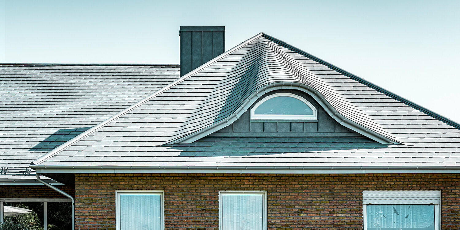 A ’70-es években épített családi ház P.10 márványszürke színű alumínium zsindelytetővel fedve, ívelt álló tetőablakkal, kerek ablakkal