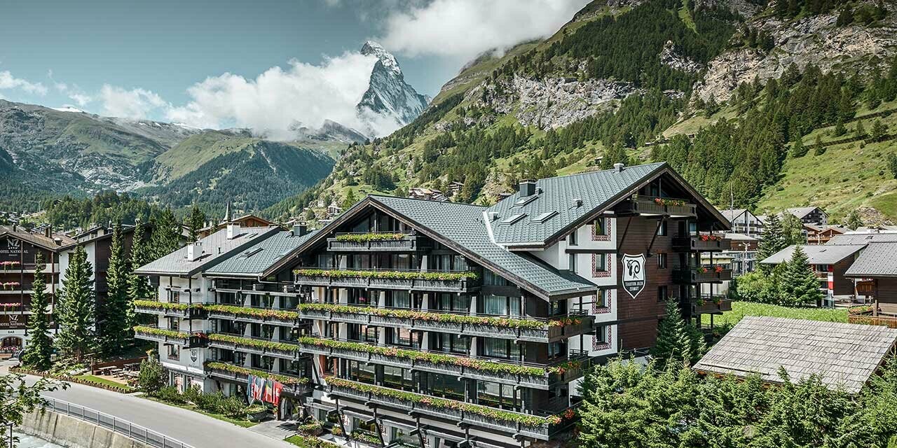 Hotel Alpenhof Zermatt, háttérben a Matterhornnal, erkélyekkel, sötét fa homlokzattal és antracit színű PREFA alumínium fedéssel