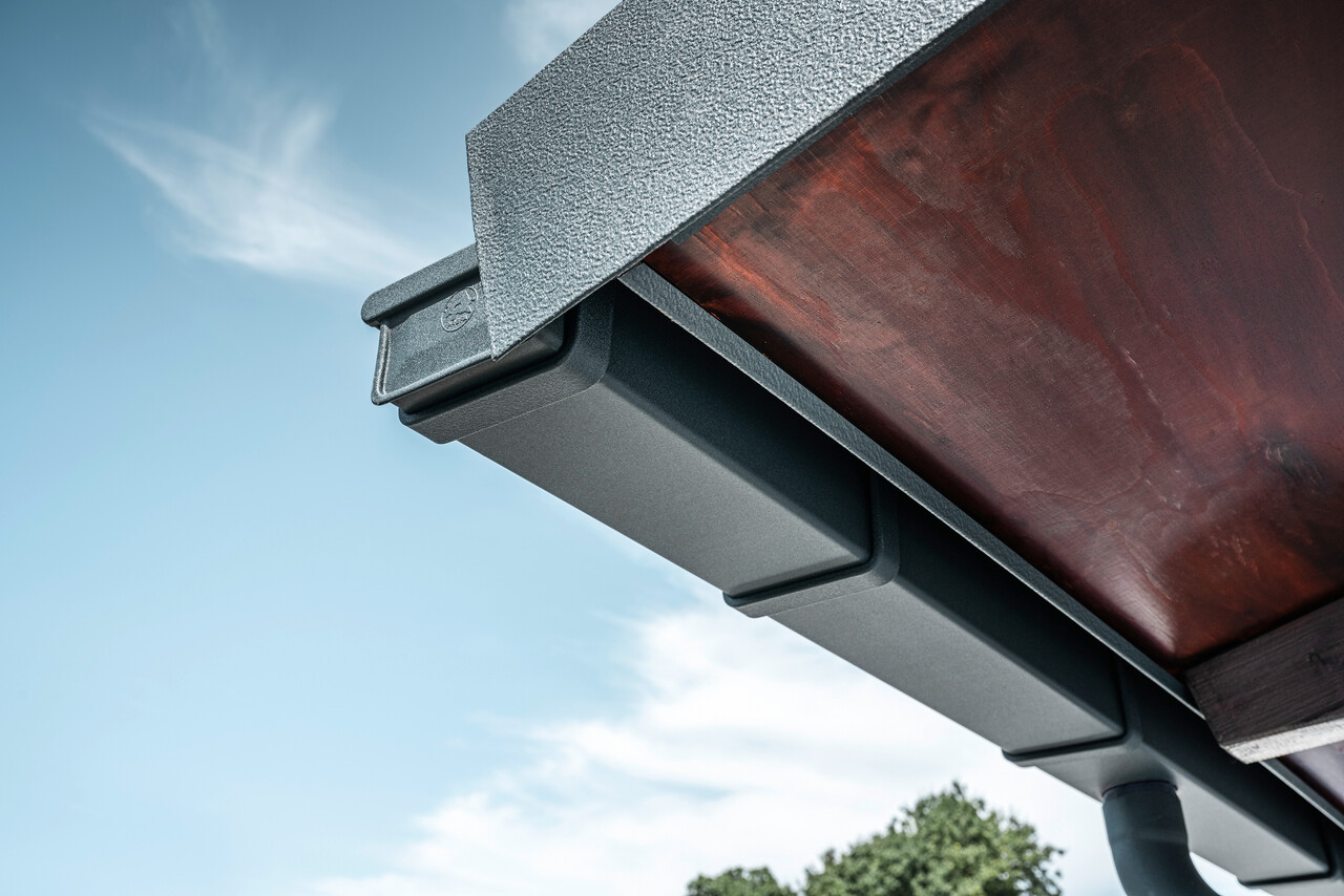 Részlet a PREFA tetővízelvezető rendszerről, P.10 antracit színben, egy családi ház tetőjén Dortmundban.