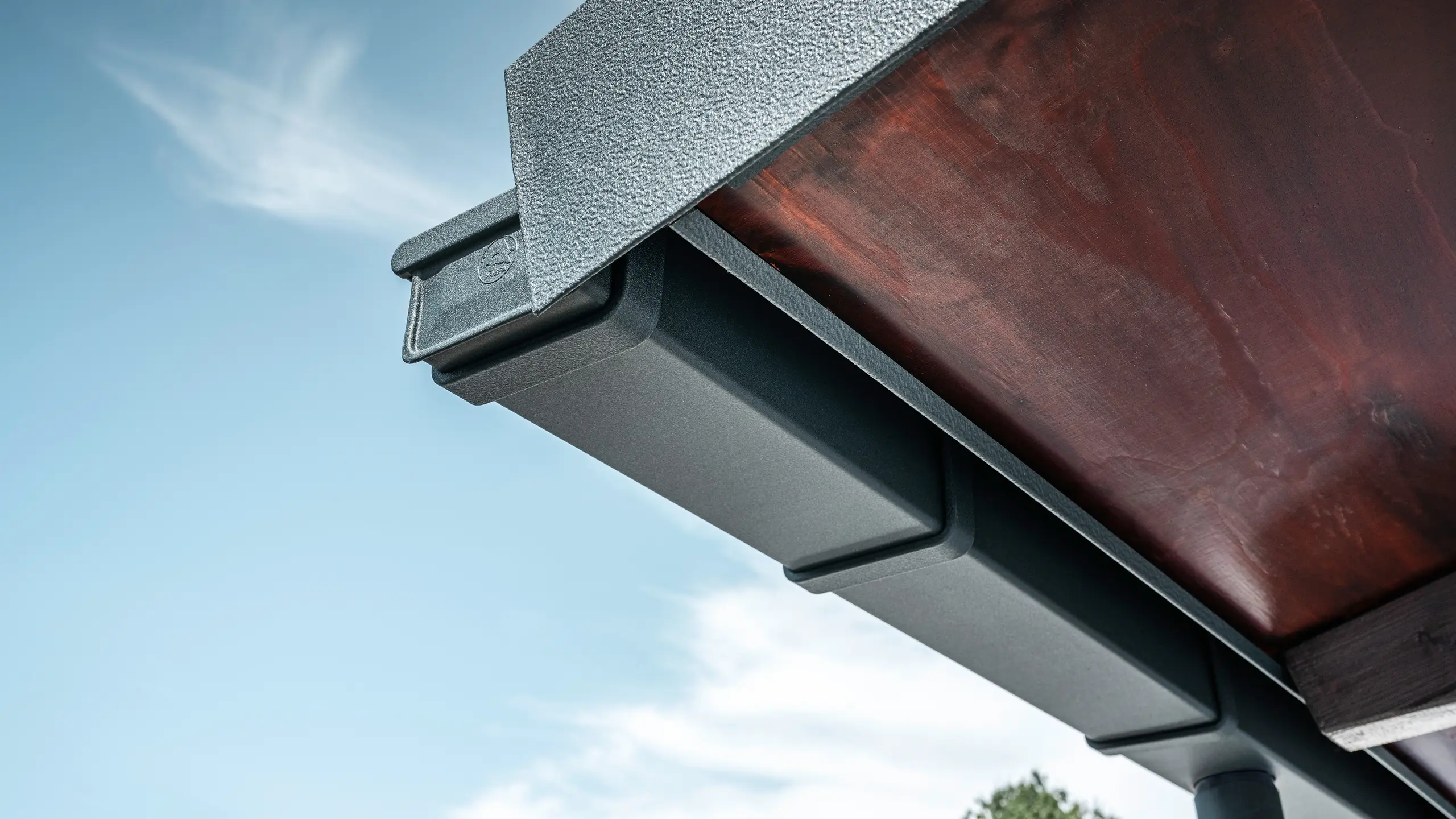 Részlet a PREFA tetővízelvezető rendszerről, P.10 antracit színben, egy családi ház tetőjén Dortmundban.
