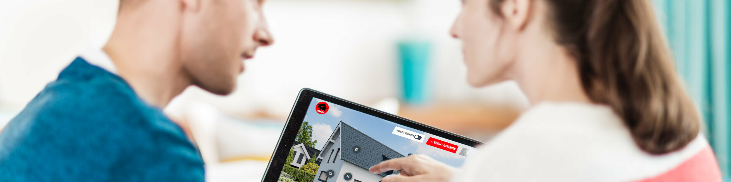 Egy pár együtt ül az asztalnál, és egy tableten egy ház digitális ábrázolását nézi tetővel, homlokzattal és alumíniumból készült napelemes elemekkel – a PREFA tetőhöz, homlokzathoz és napelemhez kapcsolódó útmutatójának kontextusában házépítéshez és felújításhoz.