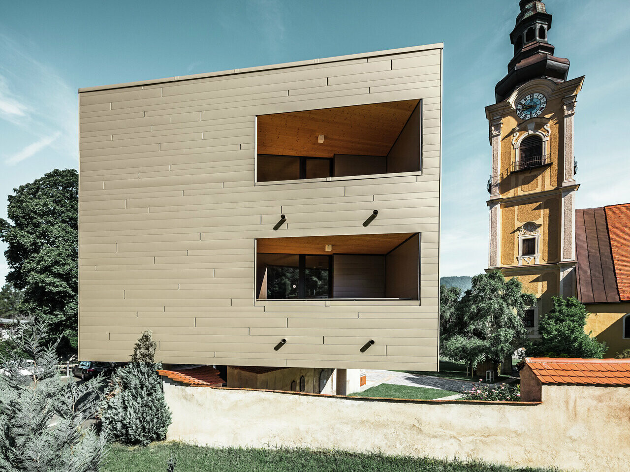 Seitenansicht des Studentenwohnheims in Leoben. Im Hintergrund ist die Kirche zu sehen.