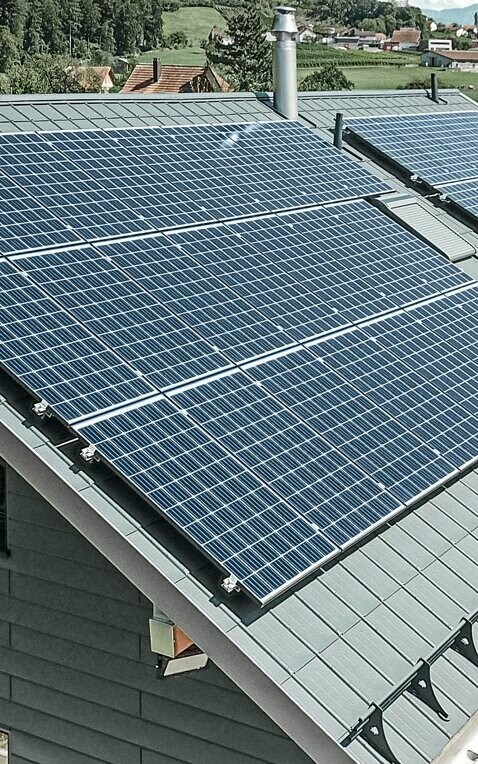 [Translate to Magyar:] PREFA Dachplatte in der Farbe anthrazit mit einer montierten Photovoltaik-Anlage als Aufdach-Lösung.
