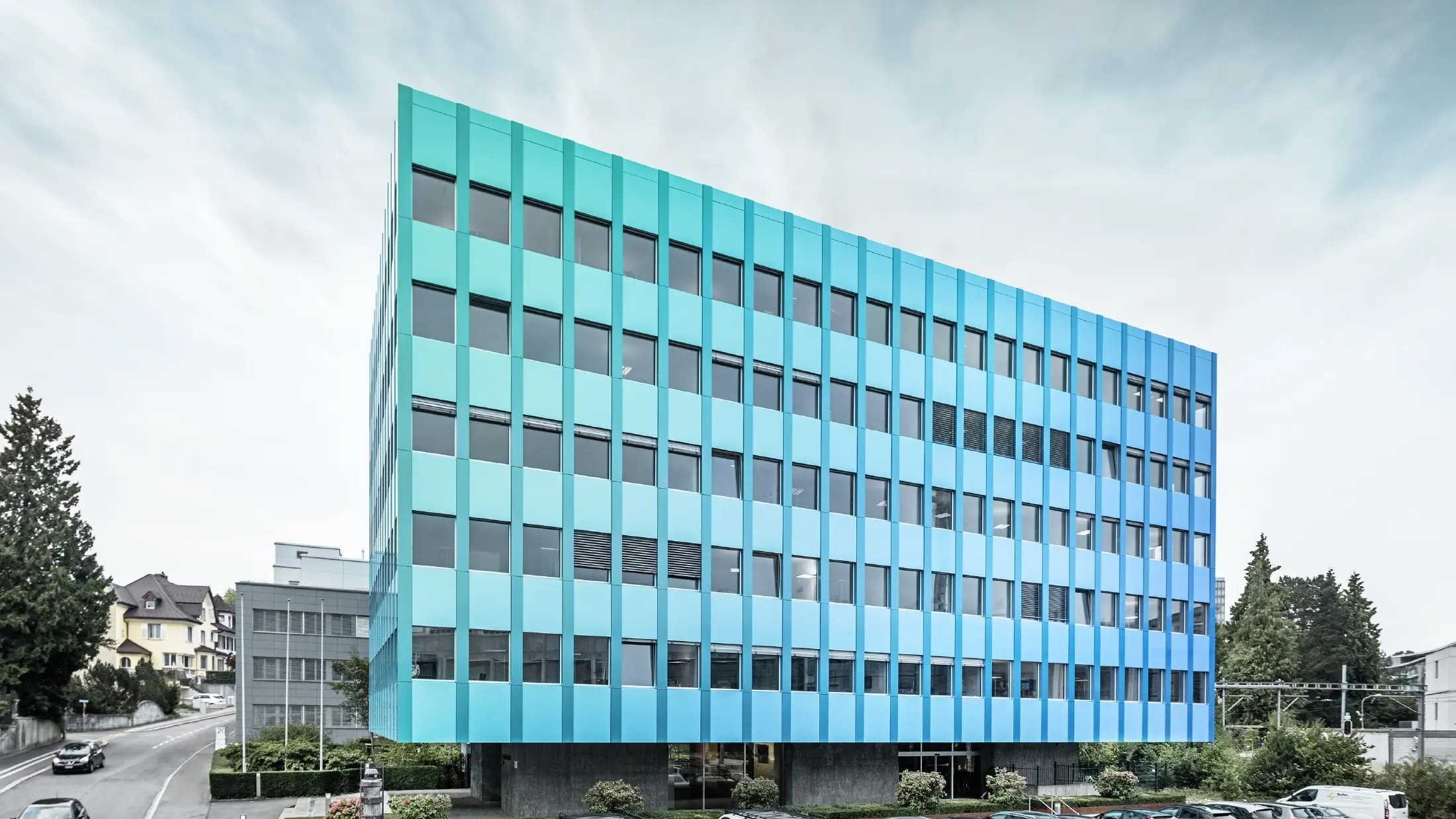A Wieland-ház oldalnézete Aarau városában; a homlokzatot PREFA PREFABOND alumínium kompozit lemezzel burkolták, amely a speciális bevonatolási eljárásnak köszönhetően kékes-zöldes árnyalatban csillog.