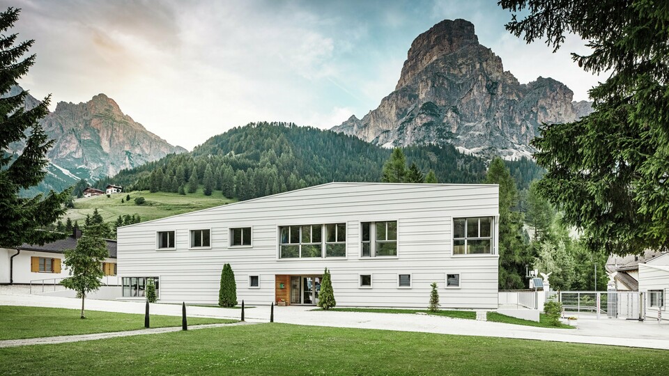 Moderne Militärarchitektur trifft auf alpine Landschaft: Die Kaserne „Tempesti“ liegt inmitten der Südtiroler Landschaft vor einer imposanten Bergkulisse. Die helle PREFALZ-Fassade in der Farbe P.10 Prefaweiß setzt klare Linien. Das helle Aluminium reflektiert das Sonnenlicht und verbessert das Raumklima.