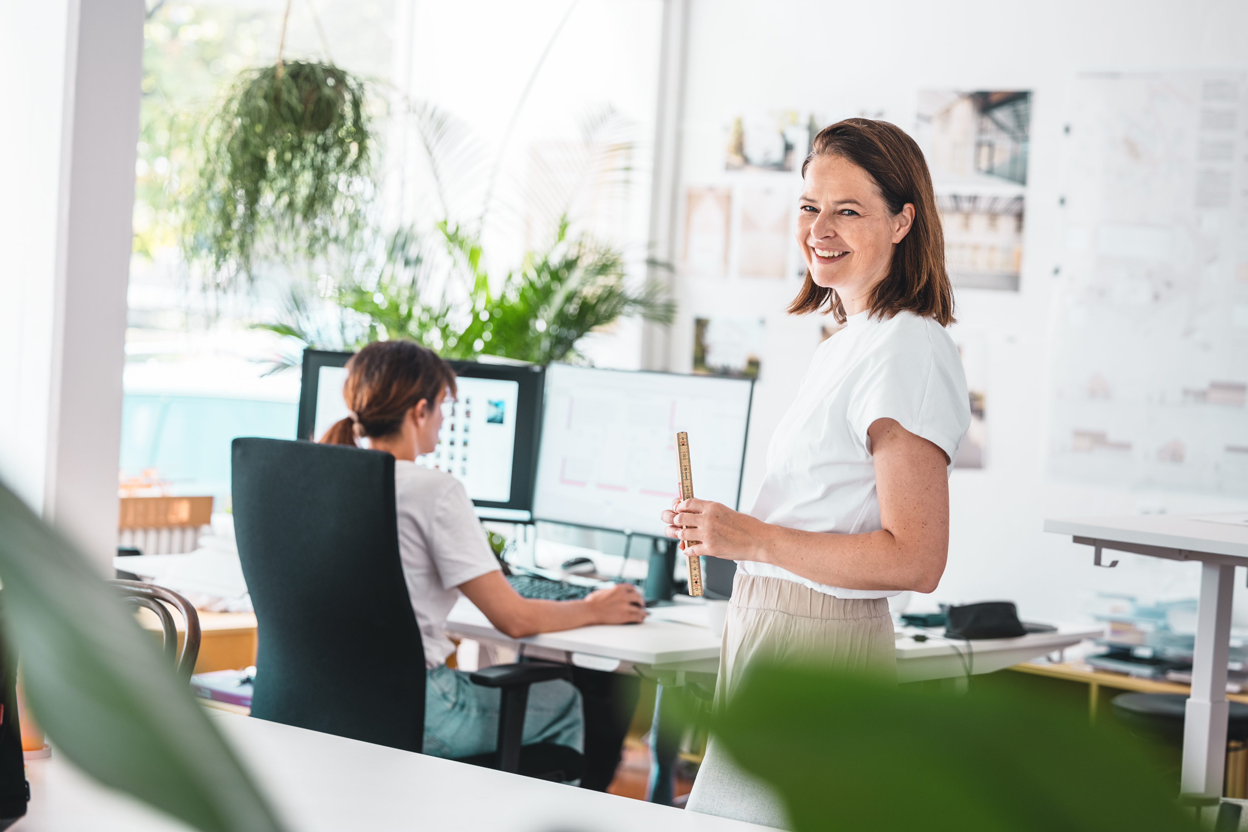 Architektin mit iPad in der Hand vor Bilderwand